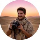 Lomonte Channeltravel, travel blogger, con foulard color sabbia e macchina fotografica professionale su una duna al tramonto